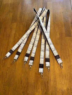 five white and black leashes laying on top of a wooden floor