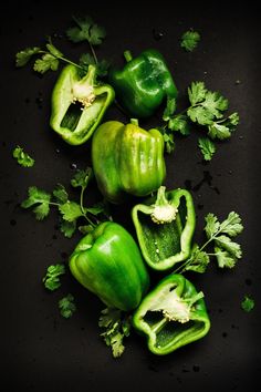 green peppers and parsley on a black surface