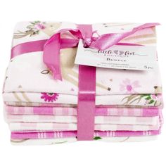 the pink ribbon is tied on top of four folded sheets with floral designs and ribbons