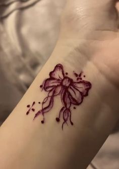 a woman's wrist with a flower tattoo on the left side of her arm