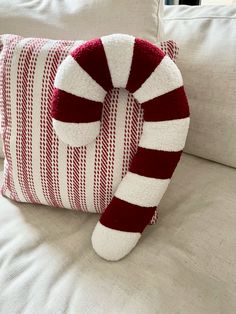 a red and white striped pillow sitting on top of a couch