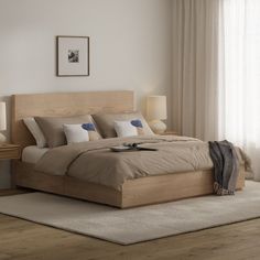 a large bed sitting next to two lamps on top of a wooden dresser in a bedroom