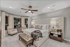 a bedroom with a large bed and ceiling fan