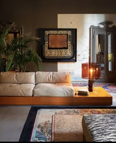 a living room filled with lots of furniture next to a tall plant in front of a mirror