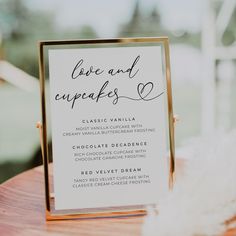 a sign that says love and cupcakes is on top of a wooden table