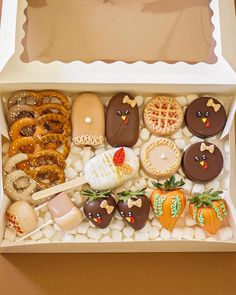 an open box filled with assorted cookies and pretzels