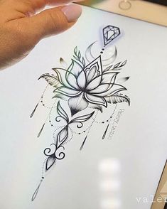 a person holding up a drawing with a diamond on it's side and a flower in the middle