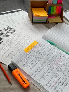 an open notebook and pen sitting on top of a table next to other writing materials