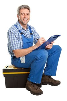 a man sitting on top of a tool box holding a clipboard