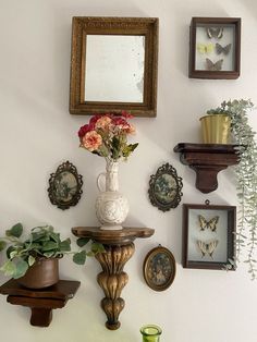 there are many pictures on the wall with flowers in vases and other things around them