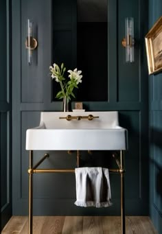 a white sink sitting under a mirror next to a wall mounted faucet in a bathroom