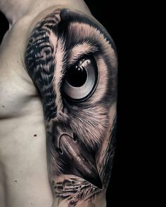 an owl tattoo on the upper half of his arm, with a black and white background