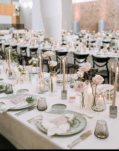 the table is set with flowers, candles and place settings for an elegant wedding reception