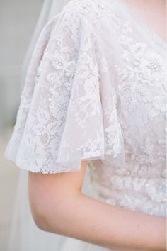 a woman in a white wedding dress holding her bouquet