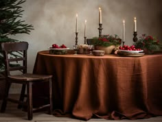 the table is set with candles and fruit on it