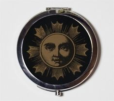 a compact mirror with an image of a man's face in the sun on it