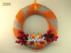 an orange and gray wreath with the words handcraft hanging on it's side