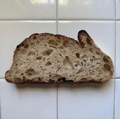 a piece of bread sitting on top of a white tiled wall