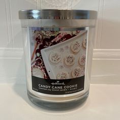 a glass jar filled with candy cane cookie cookies on top of a white countertop