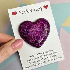 a purple heart shaped brooch sitting on top of a card