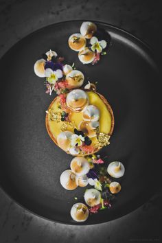 a black plate topped with food on top of a table