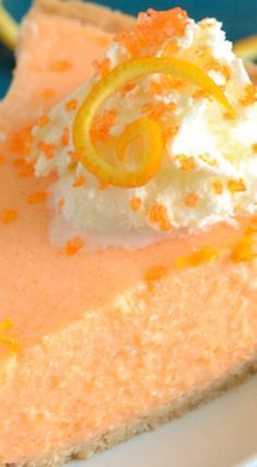 a slice of cheesecake topped with whipped cream and orange zest