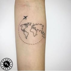 an airplane flying around the world tattoo on the right forearm and arm, with a dotted line in the middle