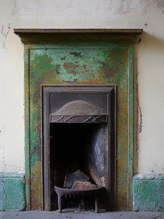 an old fireplace with peeling paint on it