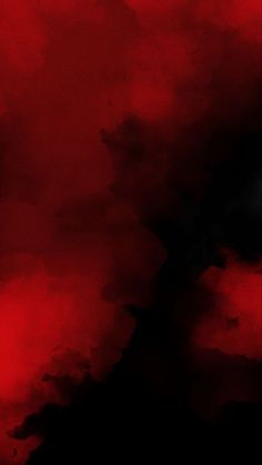 a black and red background with clouds in the sky