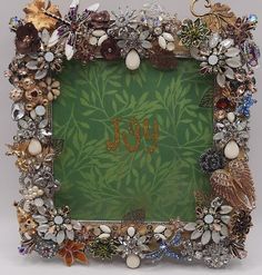 an ornate frame is adorned with jewels and other jeweled objects, including leaves and flowers