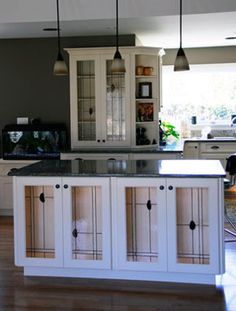 a large kitchen with white cabinets and black counter tops in the middle of an open floor plan