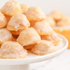 a white plate filled with powdered sugar donuts on top of a marble counter