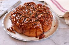 a bundt cake covered in pecans on a plate