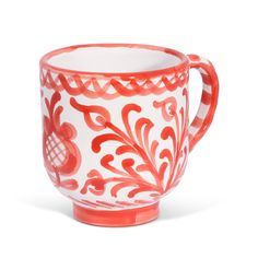 a red and white coffee cup sitting on top of a table