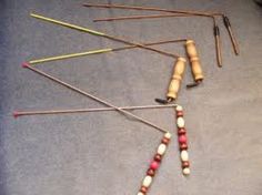 an assortment of knitting needles and crochet hooks laid out on a gray surface