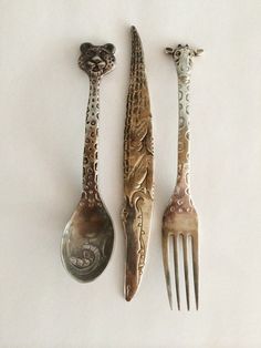 three spoons and two forks sitting next to each other