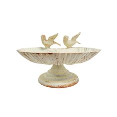 two little birds sitting on top of a bowl