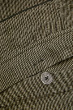 a close up view of a button on a brown jacket with black and white checkered pattern