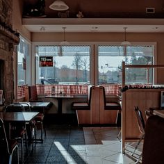 an empty restaurant with tables and chairs in front of large windows that look out onto the street