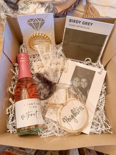 an open box containing wine, cards and other items