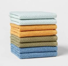 six folded towels stacked on top of each other in various colors and sizes, all with one folded