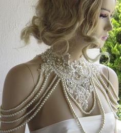 the back of a woman's dress with pearls and beading on her neck