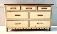 a wooden dresser with four drawers on it