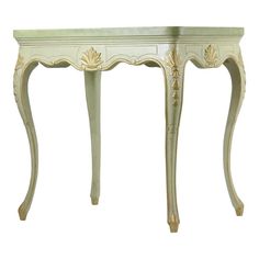 an antique console table painted in white with gold leaf accents on the top and bottom