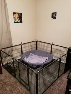 a dog pen with a shirt on top of it in the middle of a room