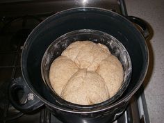 a pan filled with bread sitting on top of a stove