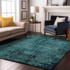 a living room filled with furniture and a green rug on top of a hard wood floor