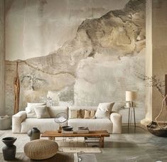 a living room filled with furniture next to a wall covered in paint and stone walls