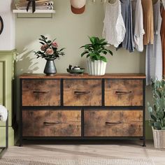 a dresser with some potted plants on top of it next to a wall mounted clock