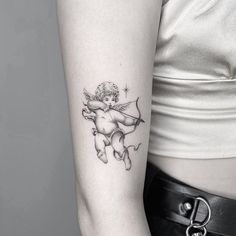 a small tattoo on the arm of a woman's left arm, depicting an angel